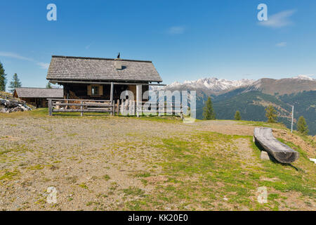 Pastore in legno lodge su un altopiano di pascolo con paesaggio alpino e montano in Carinzia occidentale, Austria. Foto Stock