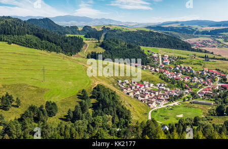 Città slovacche Stara Lubovna sul pendio erboso. bellissimo paesaggio rurale nella zona montagnosa visto dal di sopra su un giorno d'estate. Foto Stock