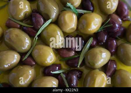 Olive nere e verdi in infusi di erbe olio d'oliva Foto Stock