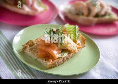 Salmone affumicato su ciabatta tostato con crema di formaggio, aneto, limone, capperi e lattuga Foto Stock