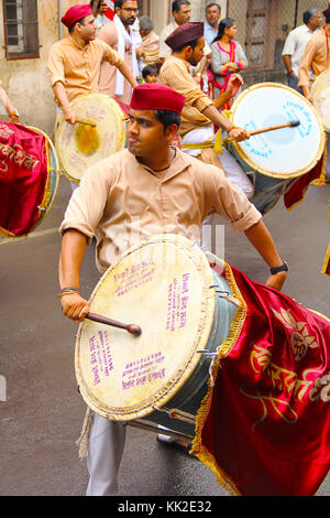 Giovane indiano, vestito tradizionalmente a giocare a dhol-taasha durante Ganapti Visarjan, Pune Foto Stock