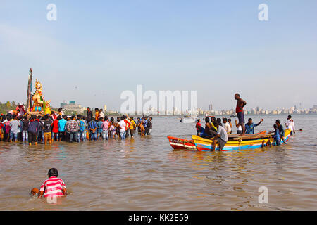 Enorme idolo Ganapati per immergersi nel mare a bordo di barche di legno, Chowpatty, Mumbai Foto Stock