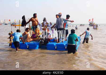 Gli idoli Ganapti si sono tenuti su una zattera galleggiante per immergersi nel Girgaon Chowpatty, Mumbai Foto Stock