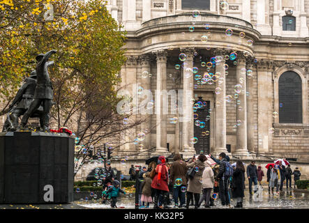 Uomo a St Pauls Cathedral intrattenere i bambini e le persone che effettuano grandi bolle, London, England, Regno Unito Foto Stock