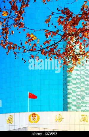 Bandiera cinese e vetro riflettente di nuove autorità portuale edificio doganale nel centro della città, Yantai, provincia di Shandong, Cina Foto Stock