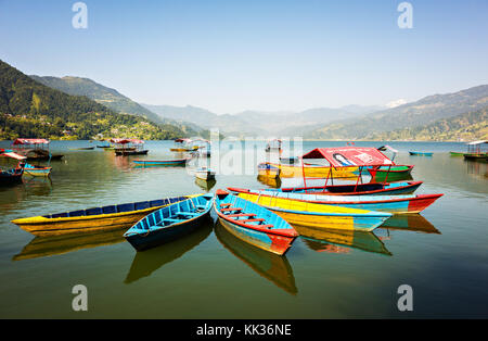 Manuale di fatti a mano imbarcazioni a remi allineate sul lago phewa, popolare attrazione turistica, mid-regione occidentale, pokhara, Nepal Foto Stock