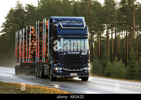 Salo, Finlandia - 24 novembre 2017: blu scania r730 carrello registrazione offre un carico di legname lungo umide autostrada nel tardo autunno nel sud della Finlandia. Foto Stock