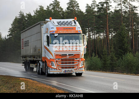 Salo, Finlandia - 24 novembre 2017: arancio e bianco volvo fh di kuljetusliike kungas ky trasporta un DB Schenker rimorchio lungo la strada bagnata in autunno in s Foto Stock