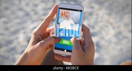 Persona messa moneta nel salvadanaio contro le mani dell'uomo utilizzando il telefono cellulare presso la spiaggia Foto Stock