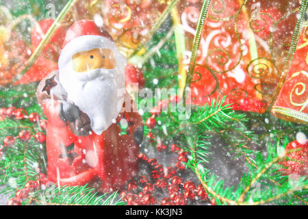 Giocattolo di natale santa claus circondato da rami di abete Foto Stock