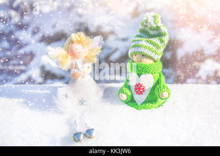 Giocattolo ragazza in legno in stile scandinavo in maglia verde vestiti sulla neve e Angelo. giocattoli di Natale Foto Stock