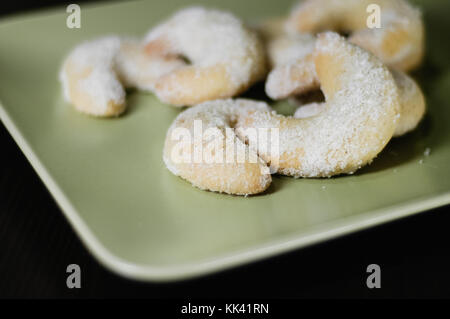 Close up fatti in casa tedesca tradizionali biscotti di Natale chiamato vanillekipferl, a forma di mezzaluna biscotti al burro con mandorle e spolverata con va Foto Stock