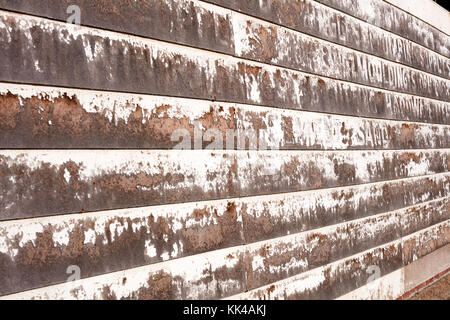 Texture di sfondo di un vecchio tavolato in legno parete in legno con resti di vernice bianca e scritte in un angolo obliquo view Foto Stock