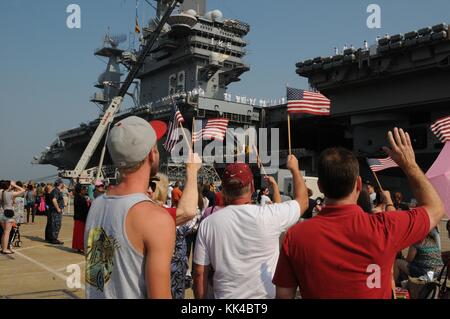 I membri della famiglia e gli amici si riuniscono come la portaerei di classe Nimitz USS Dwight D Eisenhower CVN 69 parte dalla base navale Norfolk, Norfolk, Virginia, 2012. Immagine gentilmente concessa da Mass Communication Specialist prima Classe Rafael Martie/US Navy. Foto Stock