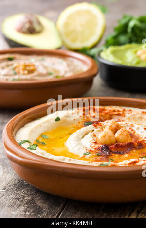 Diversi hummus bocce. ceci hummus, avocado hummus e lenticchie hummus sul tavolo di legno Foto Stock