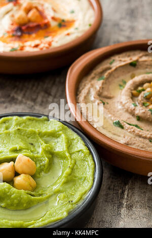 Diversi hummus bocce. ceci hummus, avocado hummus e lenticchie hummus sul tavolo di legno Foto Stock