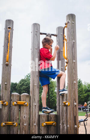 Un bambino gioca sul parco giochi in un giorno di estate Foto Stock