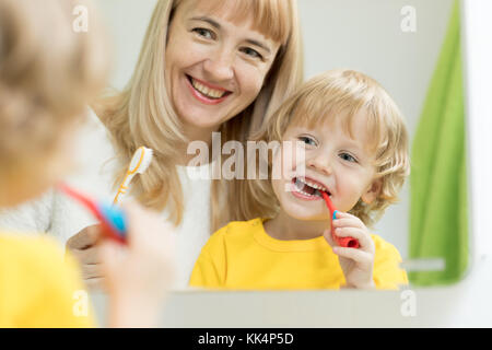 Madre insegnamento kid spazzolatura dei denti Foto Stock