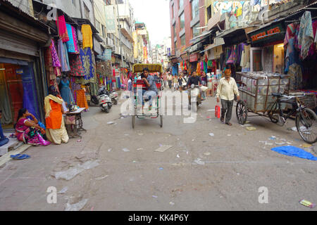 Delhi, India - 25 settembre 2017: unidentified gente camminare in una strada sporca in Paharganj, Delhi con rickshaws e un'auto-risciò. Delhi è la seconda città più popolosa in India dopo mumbai Foto Stock