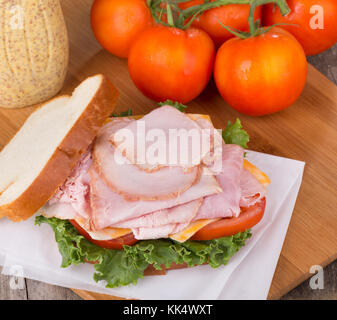 Prelibato prosciutto panino con lattuga, pomodoro e formaggio Foto Stock