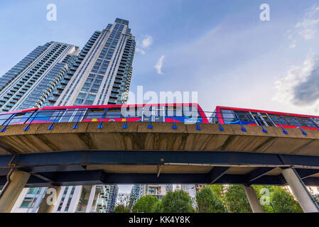 London, Regno Unito - 07 ottobre: Docklands Light Railway treno passa da canary wharf alti edifici in banchina sud su ottobre 07, 2017 in basso Foto Stock