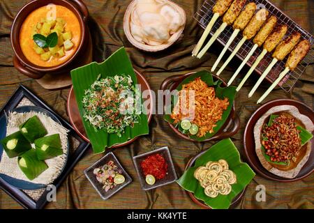 Balinese. buffet assortita di lato balinese piatti serviti in stile buffet; su una tavola rivestita con il tradizionale design balinese seseh tessuto tessile. Foto Stock