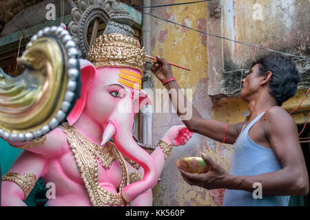 Un artigiano è occupato nel suo workshop locale per completare l'idolo non ammobiliata di dio ganesha a kumartuli ,kolkata, Foto Stock