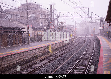 Stazione ferroviaria di curvatura di una fermata del treno in Giappone, mentre nevica pesantemente nel mezzo dell'inverno Foto Stock
