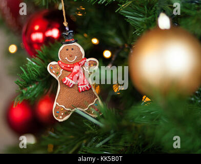 Gingerbread appeso su albero di Natale con le sfere e le luci. Foto Stock