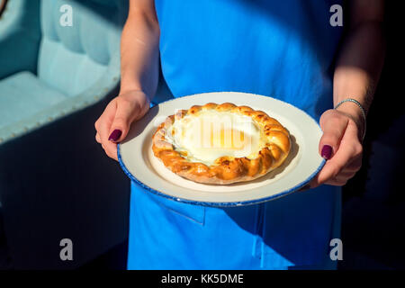 Close up donna trattiene la piastra con khachapuri Foto Stock