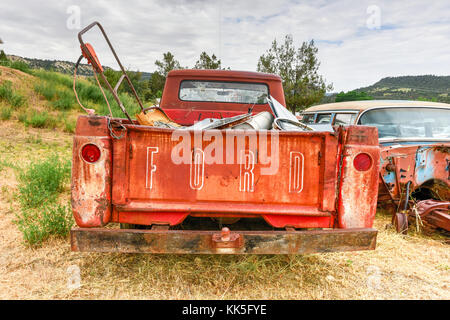 La formazione di ruggine vecchia auto in un deserto Junk Yard. Foto Stock