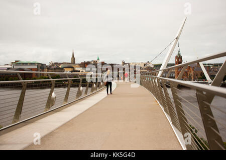 Pedoni che attraversano l'iconico Peace Bridge sul fiume Foyle a Londonderry City, nell'Irlanda del Nord Foto Stock