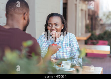 Sorridente giovane donna africana ottenendo un regalo dal suo fidanzato Foto Stock