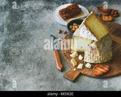 Assortimento di formaggi e spuntini su rustiche in legno, Scheda spazio di copia Foto Stock