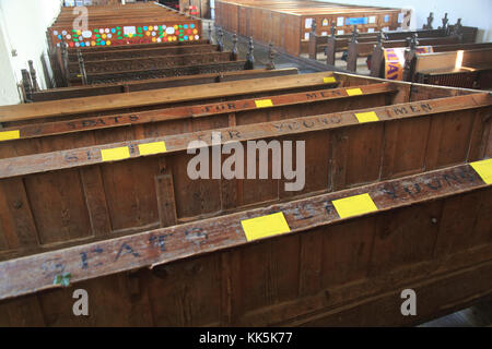 Banchi per giovani uomini all'interno della chiesa di Tutti i Santi, Laxfield, Suffolk, Inghilterra, Regno Unito Foto Stock