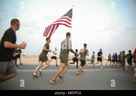 5° AREA OPERATIVA DELLA FLOTTA USA – CPL. Blake Adams, leader del team di mitragliatrici, con la Società A, 1° Battaglione, 5° reggimento marino il 15° elemento di combattimento a terra della Marine Expeditionary Unit, porta una bandiera americana durante una corsa per celebrare il 242° compleanno del corpo dei Marine, il 11 novembre 2017. Il 15° MEU è dispiegato nella 5° area di attività della flotta degli Stati Uniti a sostegno di operazioni di sicurezza marittima volte a rassicurare alleati e partner, e a preservare la libertà di navigazione e il libero flusso di commercio nella regione. Foto Stock