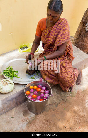 Pondicherry, PUDUCHERY, India - 04 settembre 2017. Un misterioso donna indiana fornello in strada, tagliare le verdure a pranzo. Foto Stock