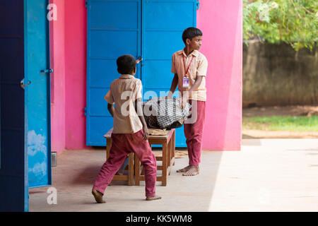 Pondicherry, PUDUCHERY, India - 04 settembre 2017. Ragazzi non identificato i bambini portare la piastra per essere servito presso la mensa per esterni. Foto Stock