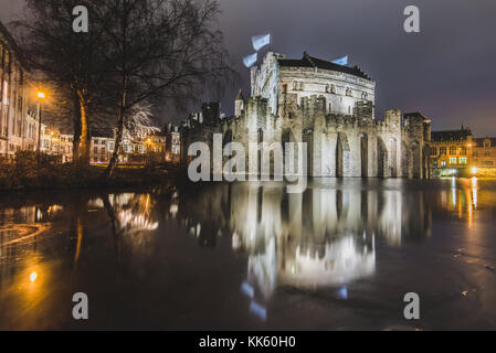 Notte Gravensteen visualizza - storico castello medievale su acqua di Gand, Fiandre, in Belgio. Castello dei Conti roccaforte riflessa sul canal nella città di Gent Foto Stock