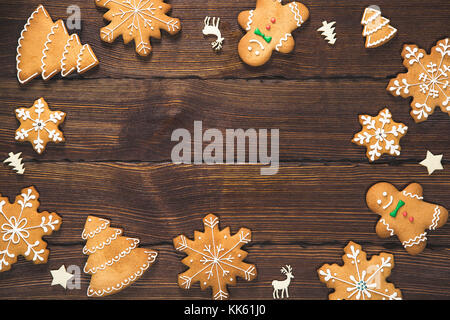 Natale gingerbread e decorazioni in forma di un telaio in legno marrone background. Composizione di natale. flat laico, vista dall'alto, spazio libero Foto Stock