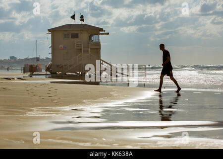 Uomo venire a riva dal mare su di una giornata invernale a Tel Aviv. Foto Stock