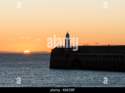 Faro sul porto di Folkestone braccio presso sunrise, Kent Foto Stock