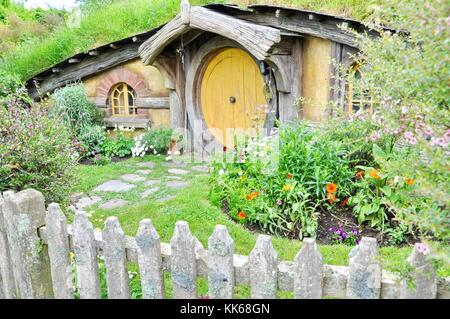 Matamata - NUOVA ZELANDA - novembre 2016 : hobbit house con una gialla porta alla hobbiton movie set. Foto Stock