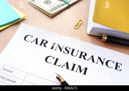 Assicurazione auto rivendicazione e denaro su un tavolo. Foto Stock