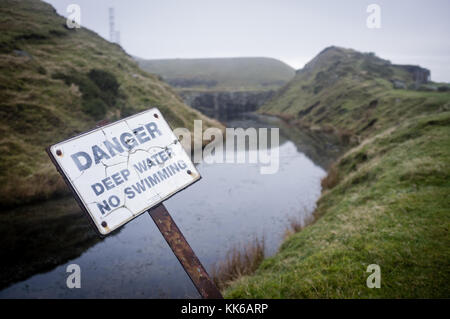 Segnaletica di pericolo - acqua profonda da una cava abbandonata la piscina nello Shropshire, Regno Unito Foto Stock