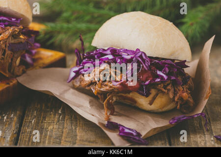 In casa barbecue hamburger di manzo con croccante di cavolo rosso slaw sul tavolo rustico. barbecue sandwich a base di carne per il pranzo di natale Foto Stock