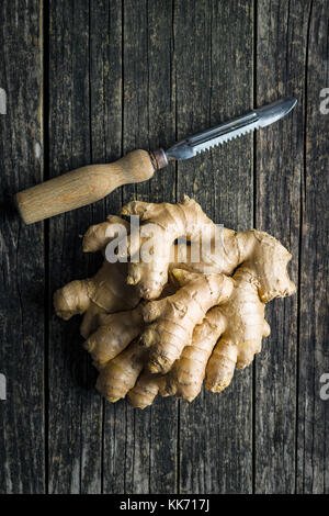 Un sano di radice di zenzero sul vecchio tavolo in legno. Foto Stock