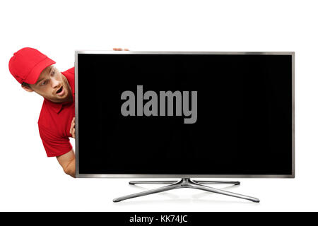 Sorpreso giovane uomo in rosso uniforme guardando grandi vuoto sullo schermo tv Foto Stock