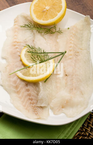 Foto di saporito affumicato spigola pesce con le fette di limone e finocchio su di esso Foto Stock