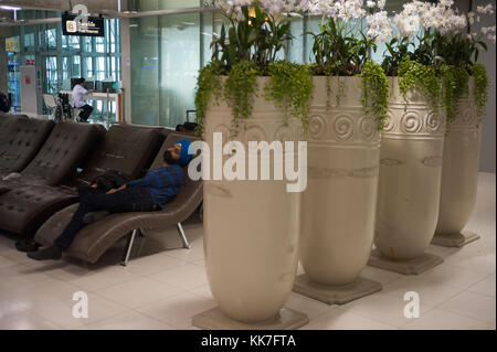 Bangkok, Thailandia, passeggero dorme nella zona di partenza all'aeroporto di Bangkok